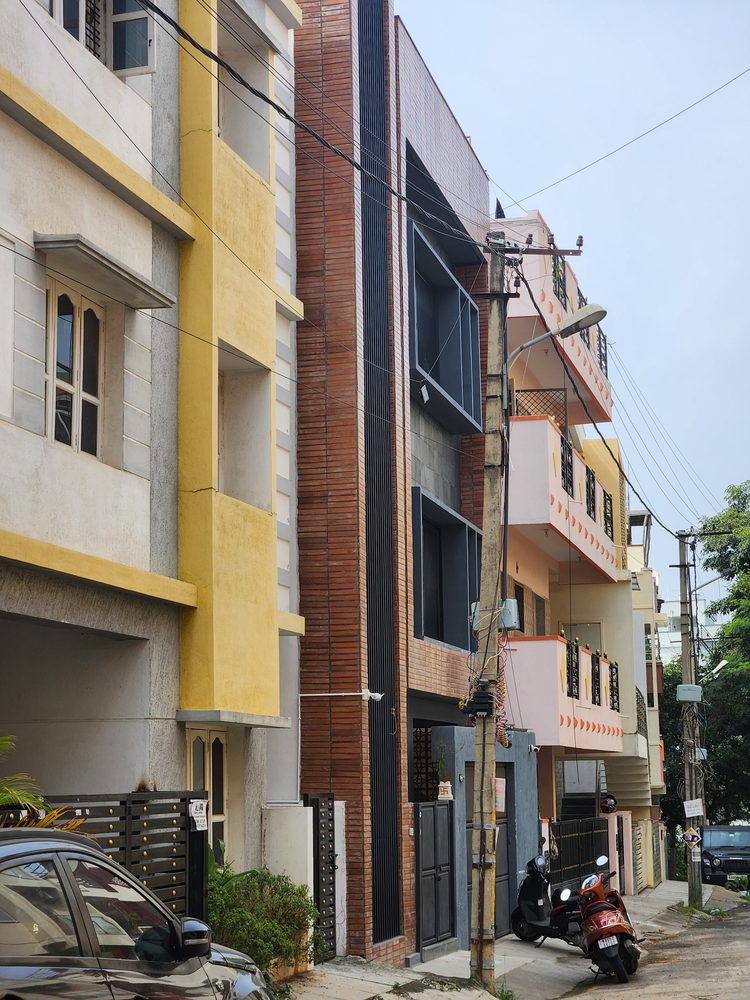 House of Volumes — The slender brick volume in its context